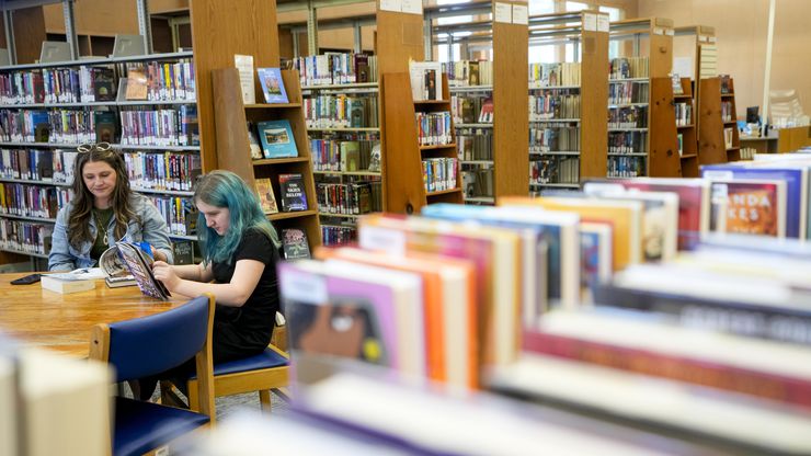 Mother and daughter read in a library, Thursday, May 18, 2023.